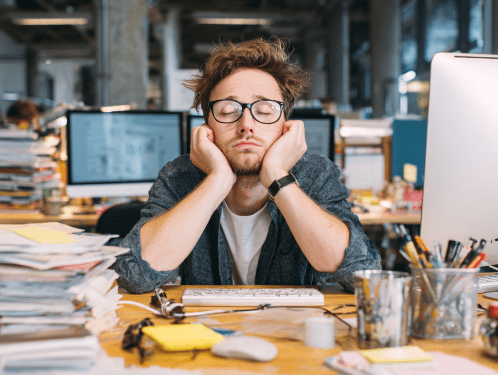 Frustrated person surrounded by paperwork.