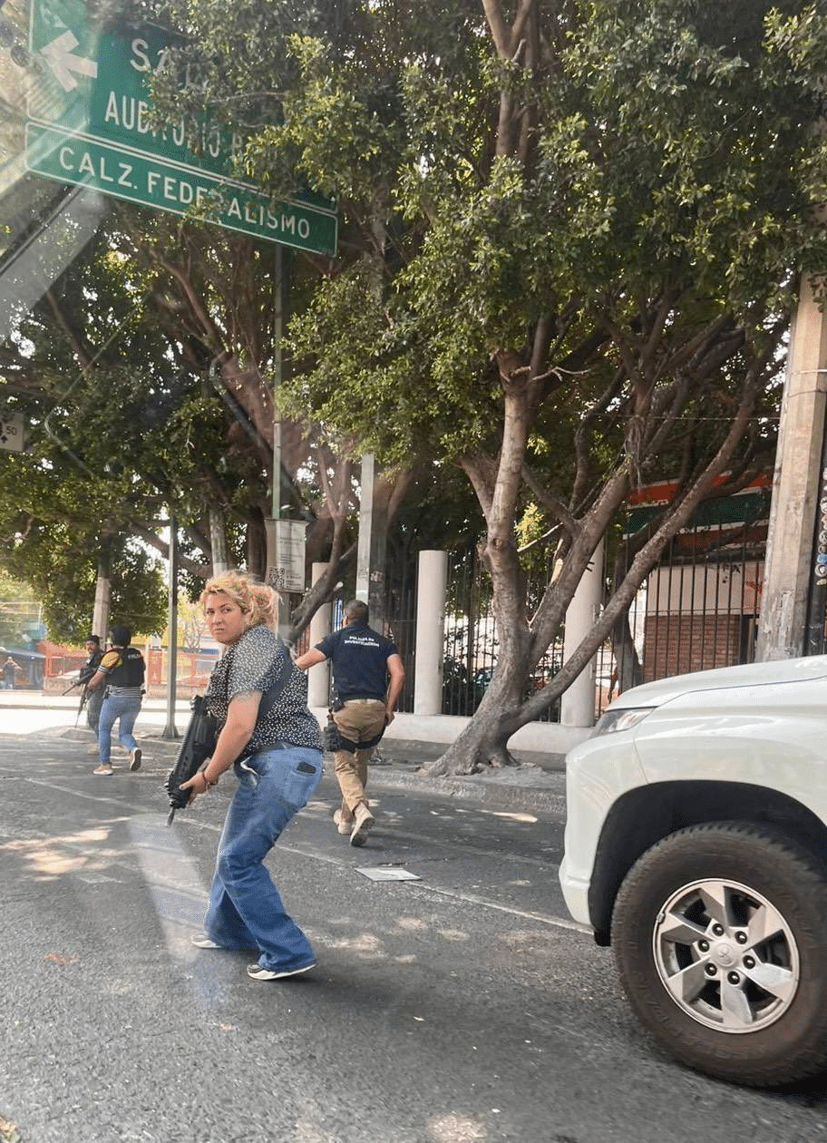 Armed police investigators on Calzada Federalismo Guadalajara during CJNG cartel unrest after El Mencho killing