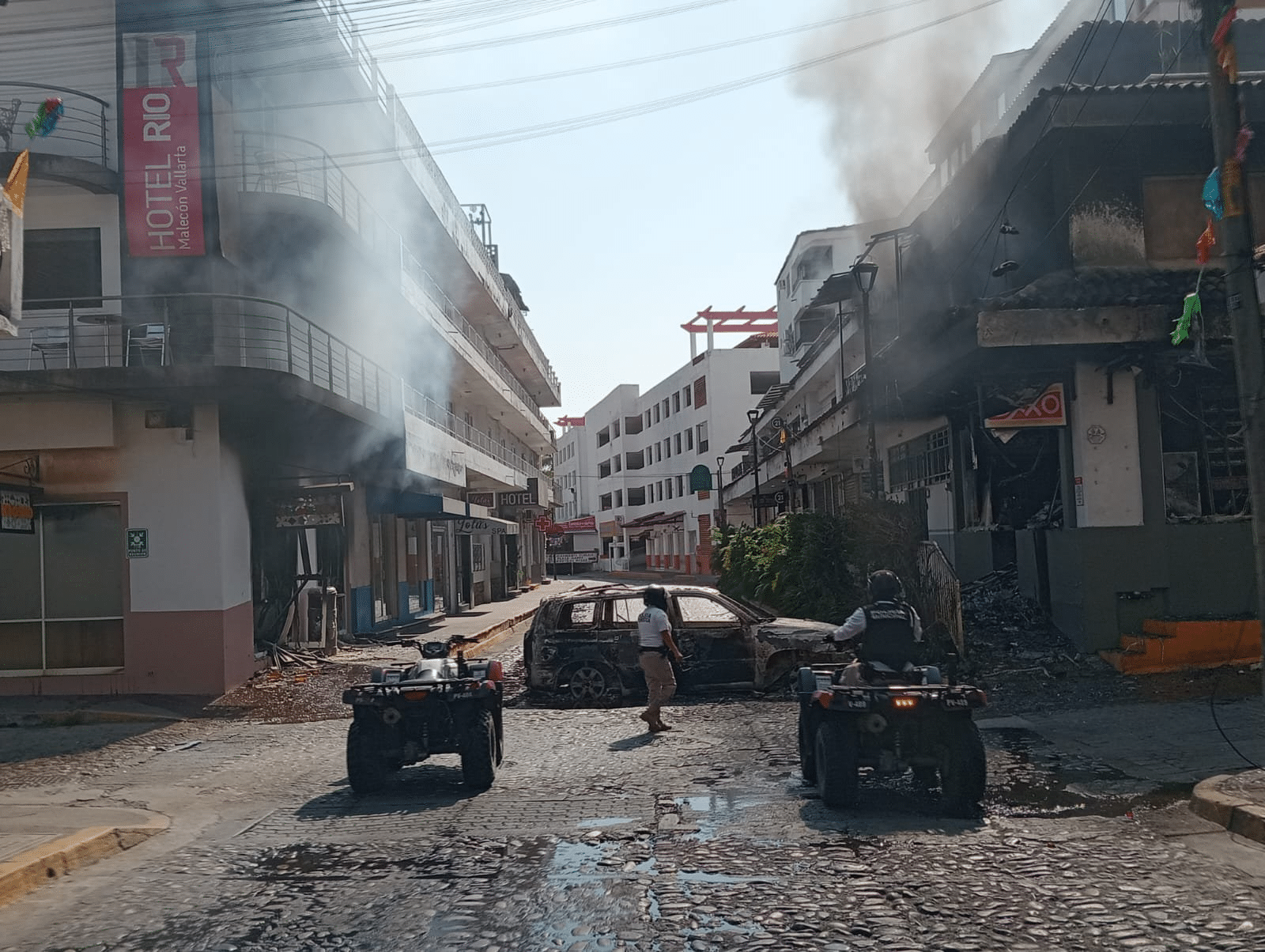 Burnt SUV and municipal police ATVs on the Malecon Puerto Vallarta during CJNG cartel violence