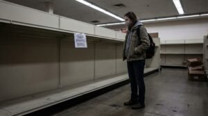 Millennial woman facing empty grocery shelves after SNAP food stamp benefits denied in 2026